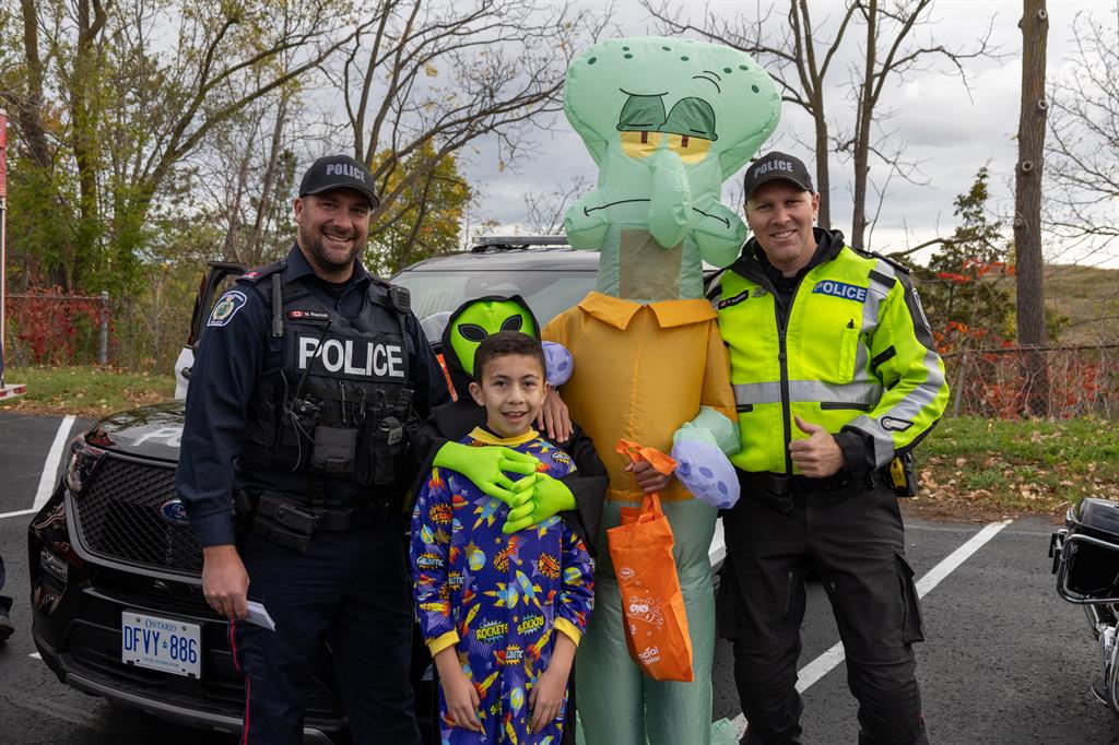 Two boys in Halloween costumes with police officers